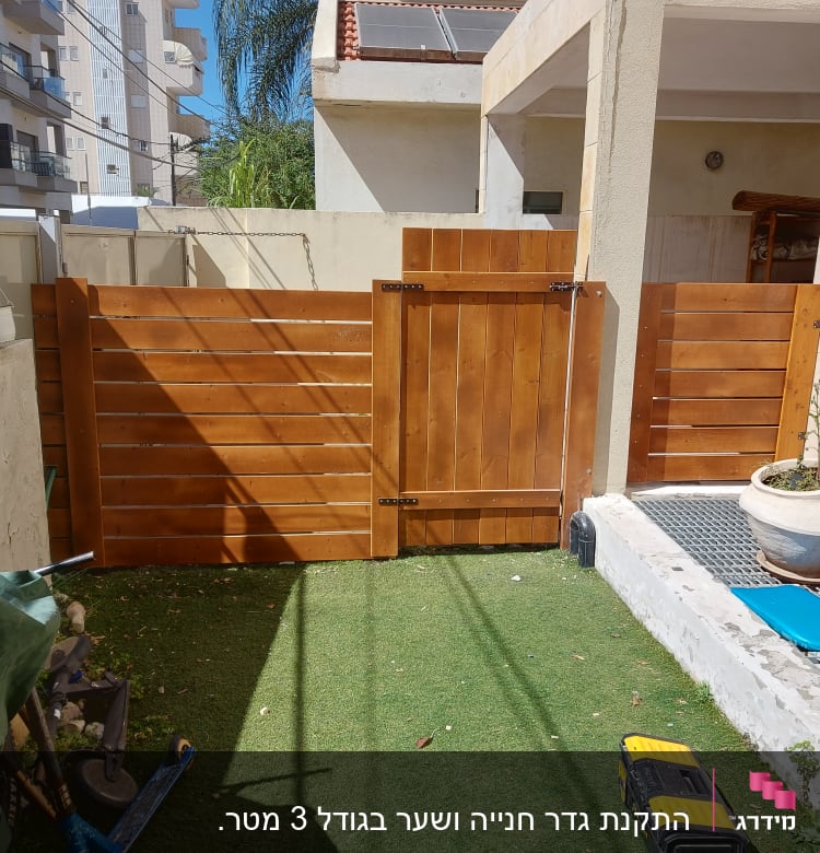 גדר עץ חומה עם שער בגינה קטנה